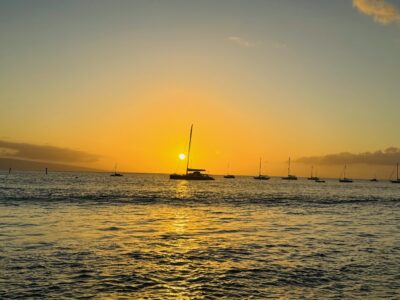View of sailboat in Lahaina harbor at sunset
